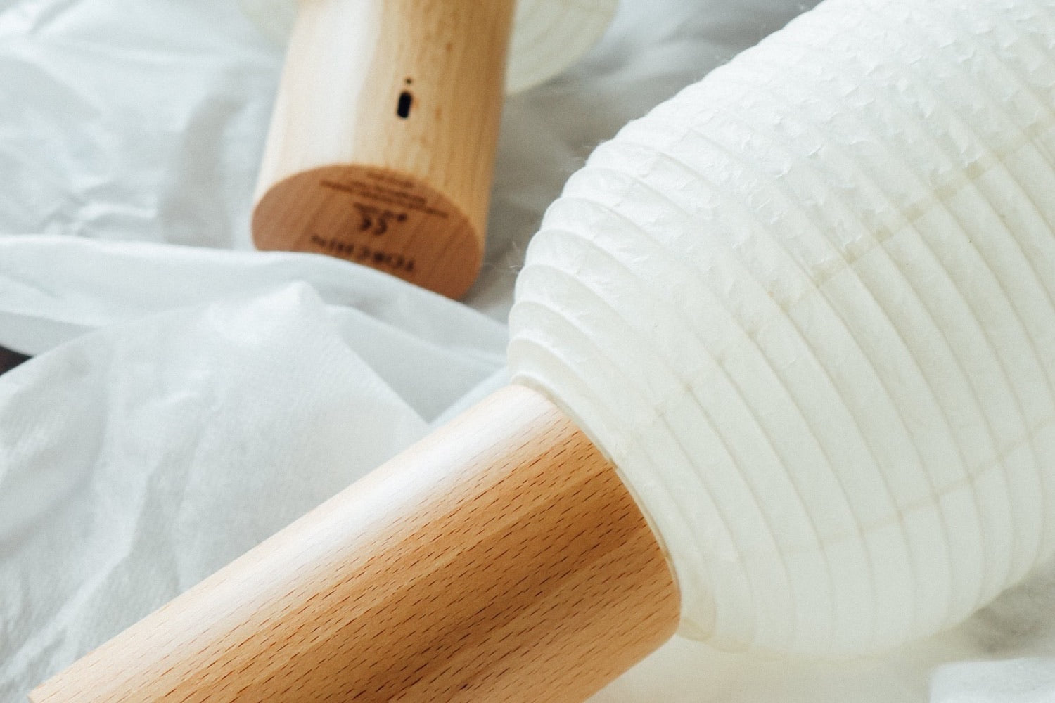 Détail d'une lampe TORCHIN, papier washi et socle en hêtre