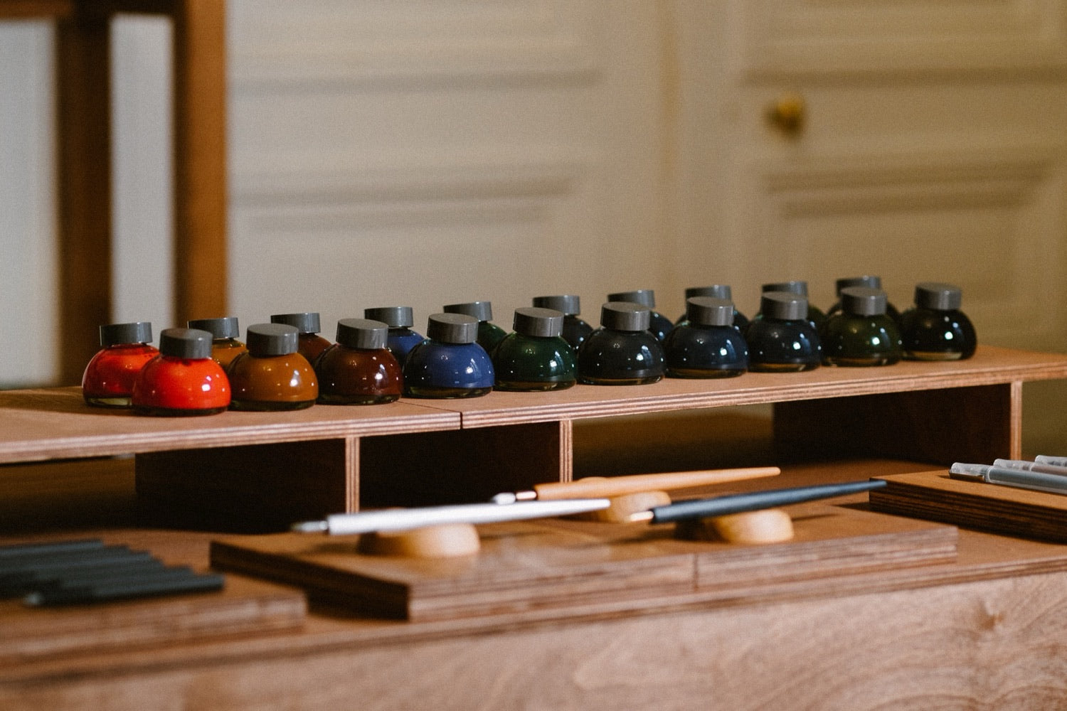 Atelier d'écriture KAKIMORI, encres et outils sur un meuble en bois