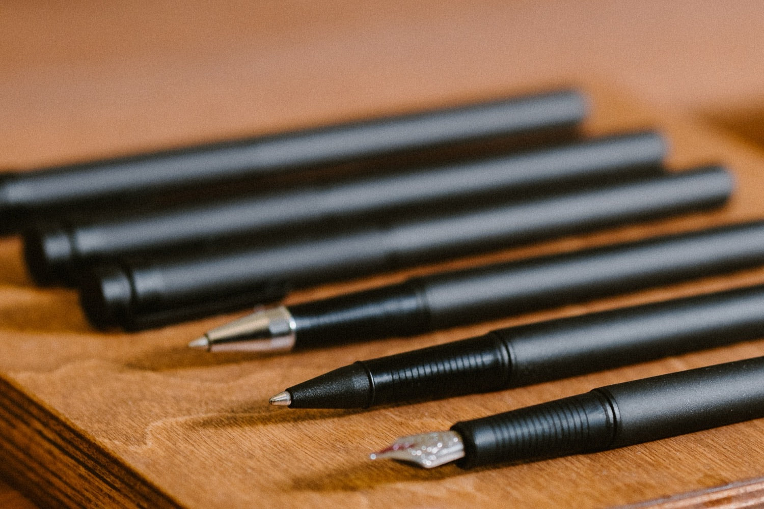 Stylos KAKIMORI en aluminium noir sur un plateau en bois